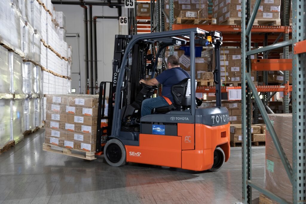 Worker operating forklift in warehouse