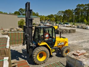 Yellow JCB forklift handling materials at construction site