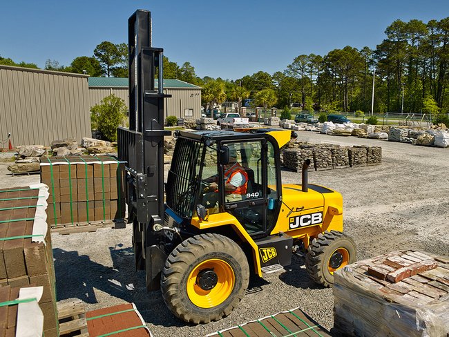 Yellow JCB forklift handling materials at construction site