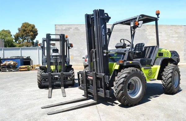 Two industrial forklifts in outdoor storage area