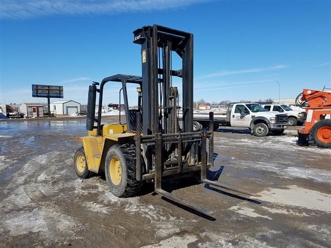 Yellow forklift in snowy outdoor industrial lot