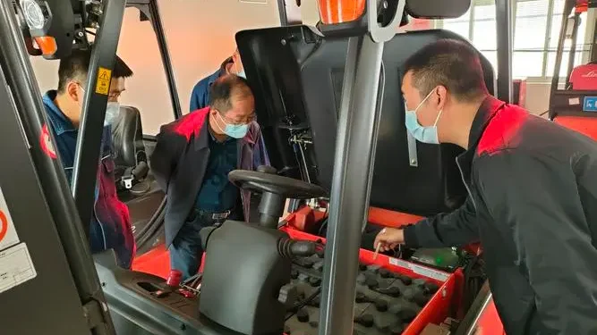 Technicians inspecting tractor in workshop